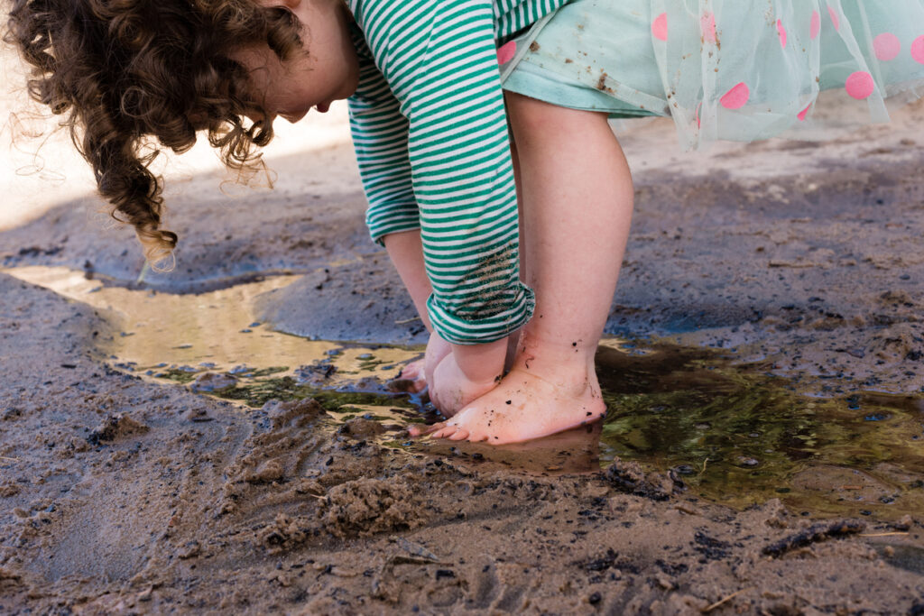 Barefoot toddler playing in sand and water - Childcare Consultant in Sydney